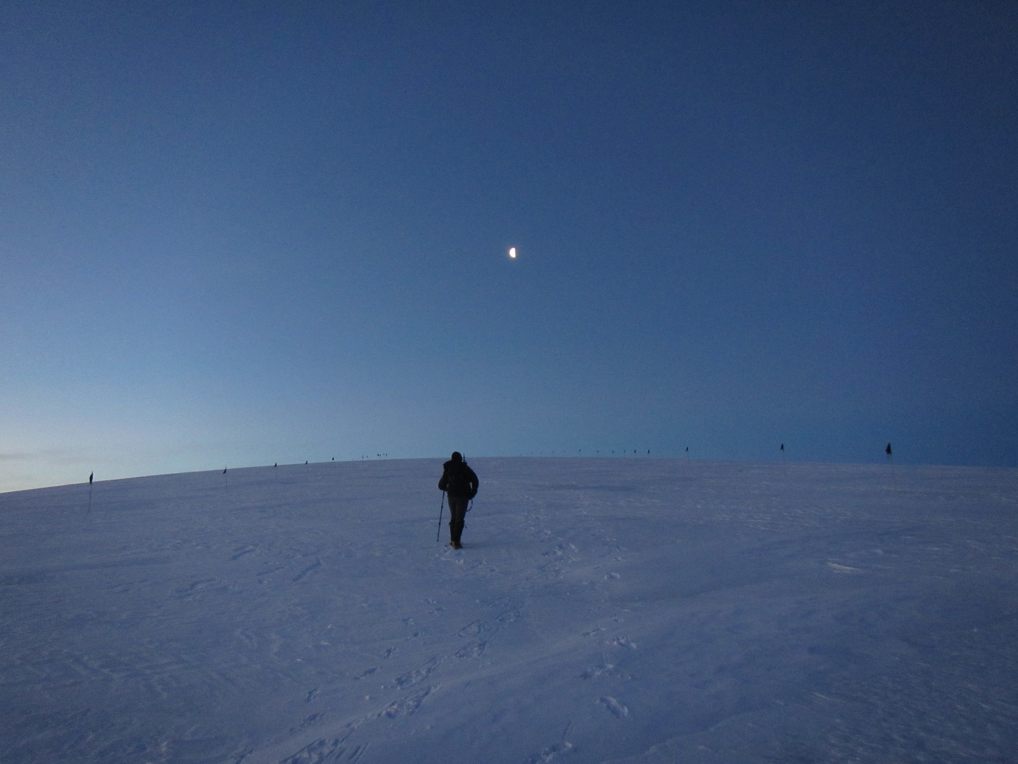 Spring days bring a twilight that last for hours. Greg makes his way up the glacier toward the rising moon.