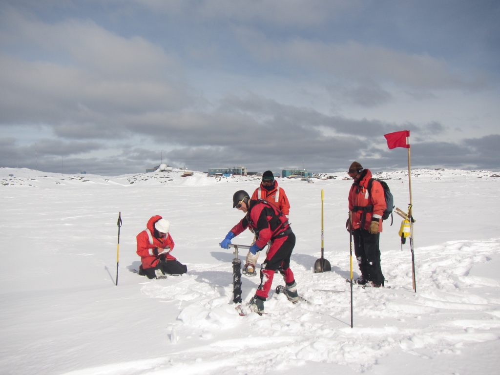 Polar microbiologist Jeff Bowman (who maintains his own blog here) uses an ice corer to establish a bore hole through the sea ice near Palmer Station, as Nicole Couto (a graduate student at Rutgers University) and members of Palmer's Glacier Search and Rescue Team, provide needed support and encouragement. 