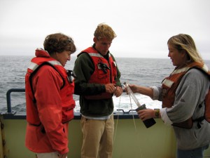 Amy, graduate student Dave Sutherland, and SSSG Marine Technician Alison Heater collect a water sample. (Woods Hole Oceanographic Institution)