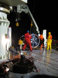 At around 1:00 a.m., EST, an hour or so after the yellow buoyancy sphere went overboard and the mooring deployment officially began, the crew wrestles the first of the two SALP frames into position. (Photo by Donovan Hohn, Woods Hole Oceanographic Institution)