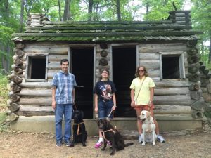 Classmates Preston and Rebecca with their new dogs, and myself and Hugger (right) in front of a commander's cabin at Jockey Hollow State Park. 
